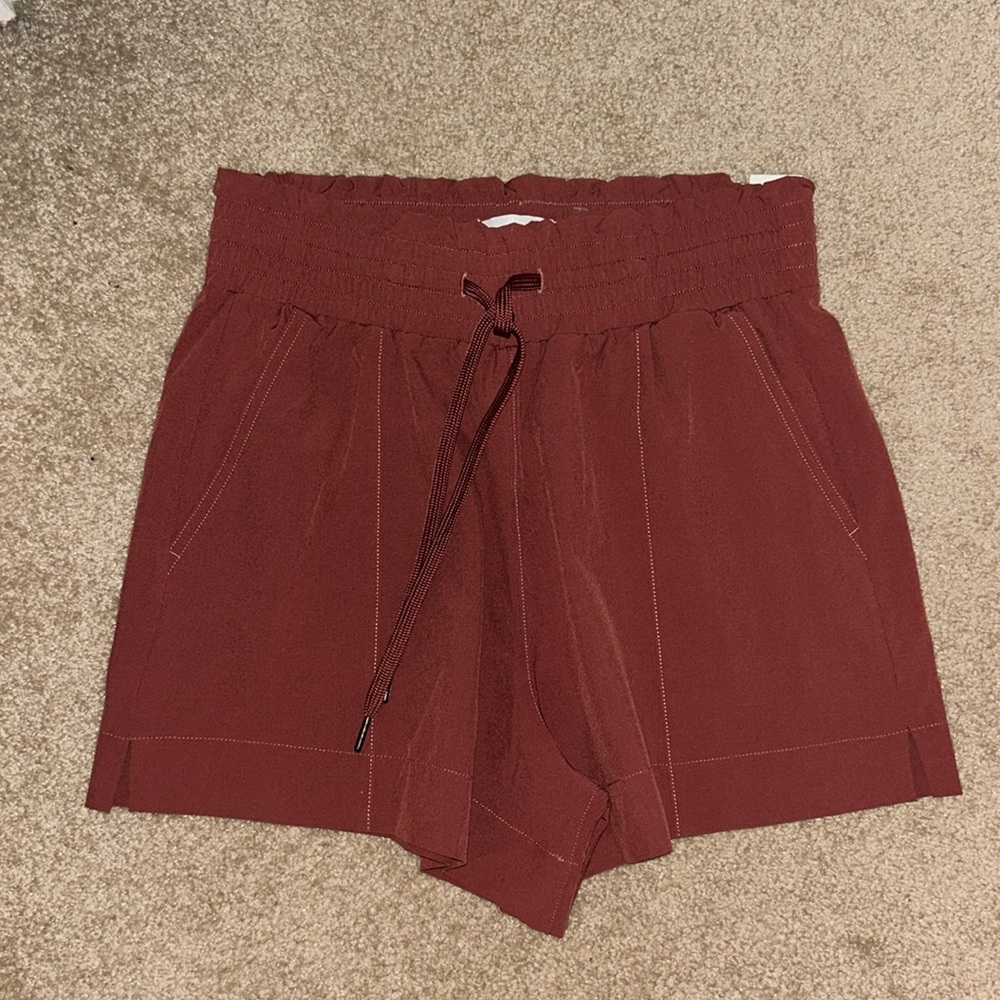 Never worn. NWT. A&F Womens athletic shorts. Color is rusty red. Size S.